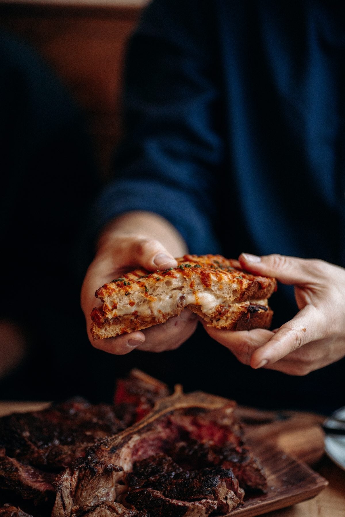 Grilled cheese à la viande tenu à deux mains au Gueuleton Montréal